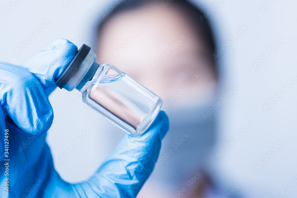 Fototapeta premium woman doctor or scientist wearing face mask protective in lab holding medicine liquid vaccines