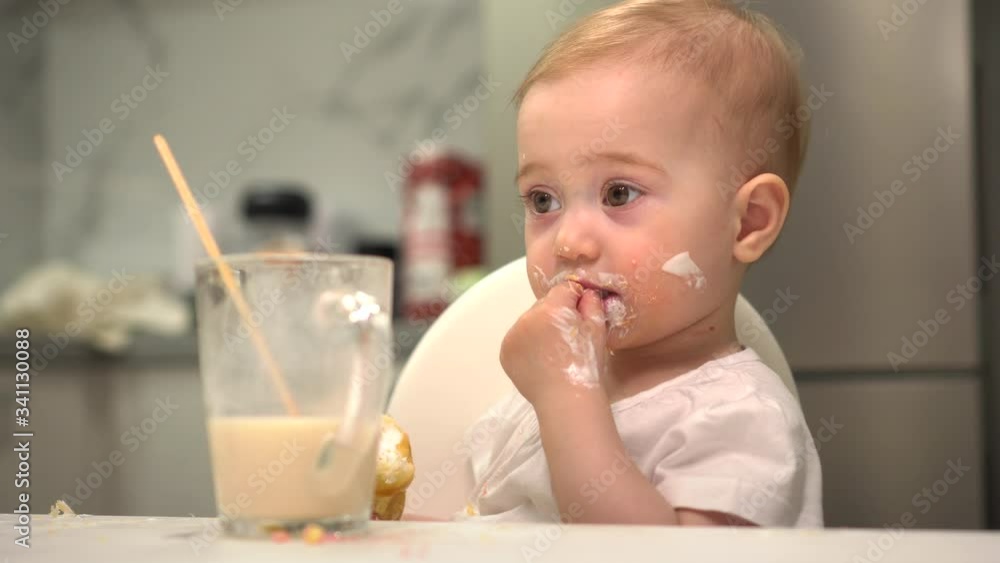 baby in the kitchen eagerly eating the delicious cream horns, filled with a vanilla cream baby in the kitchen eagerly eating the delicious cream horns, filled with a vanilla cream