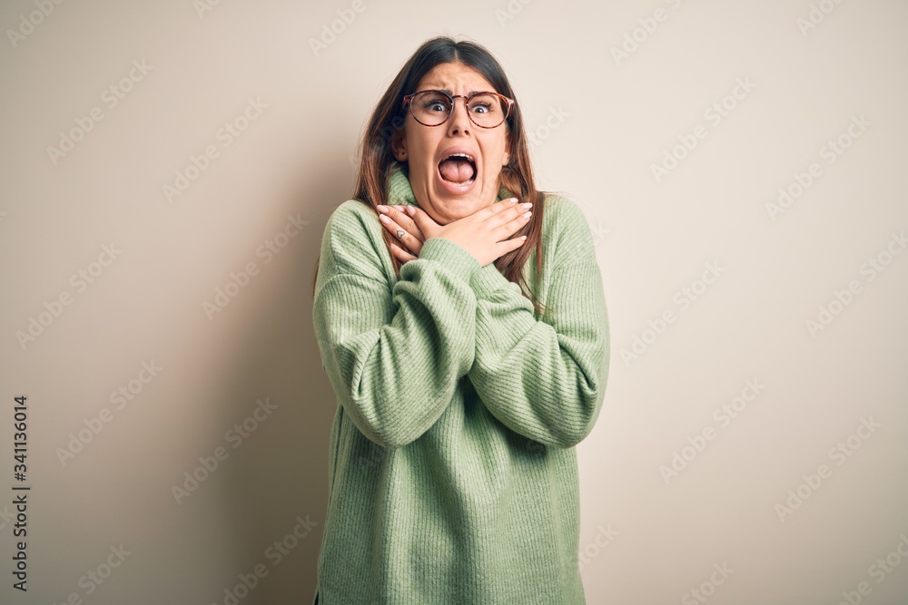 Young beautiful woman wearing casual sweater standing over isolated white background shouting and suffocate because painful strangle. Health problem. Asphyxiate and suicide concept. Young beautiful woman wearing casual sweater standing over isolated white background shouting and suffocate because painful strangle. Health problem. Asphyxiate and suicide concept.