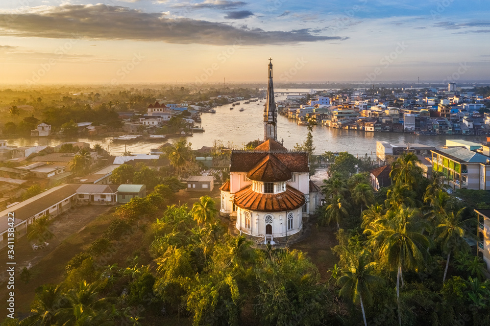 Aerial view of the famous Cai Be church in the Mekong Delta, Roman architectural style. In front is Cai Be floating market, Tien Giang, Vietnam