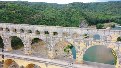 Low altitude aerial of Pont du Gard is an ancient Roman aqueduct that crosses the Gardon River near the town of Vers-Pont-du-Gard in southern France and popular tourist destination 4k