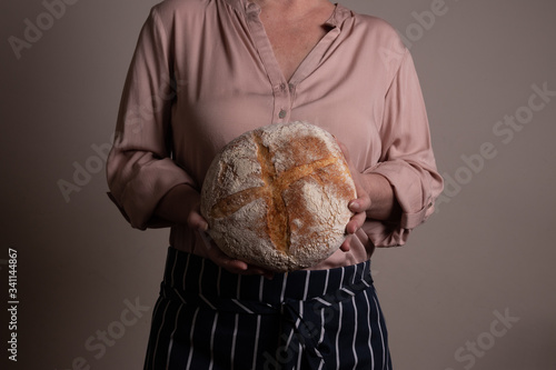 Bela mulher branca ocidental segurando um Pão Italiano de fermentação natural rústica photo