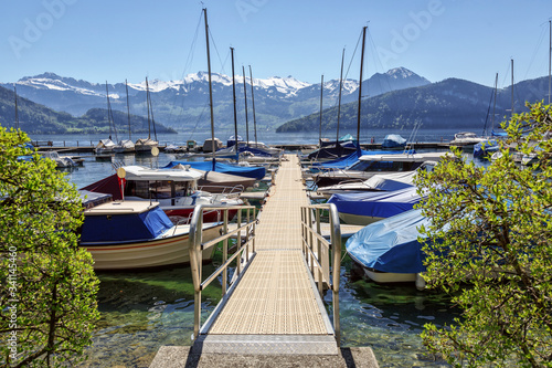 Boat harbour on the lake Lucerne overlooking the snow-capped Alps. Canton of Lucerne, Switzerland.