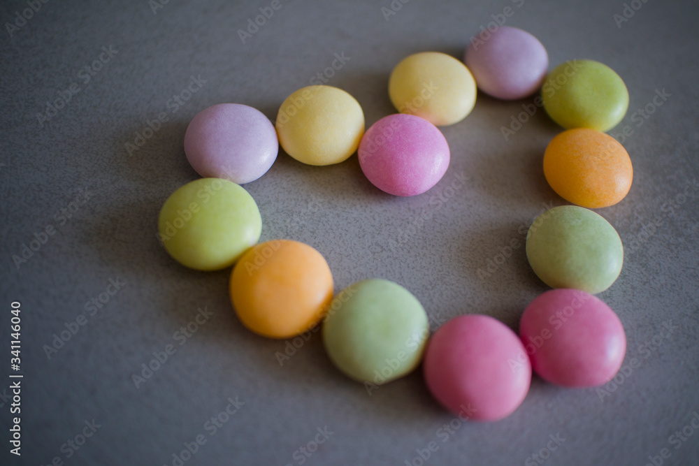 heart made of colorful candies on a gray table heart made of colorful candies on a gray table