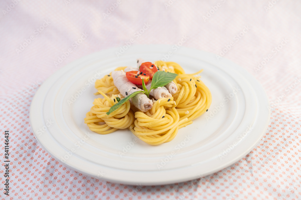 Stir-fried spaghetti and pork, beautifully arranged in a white plate.
