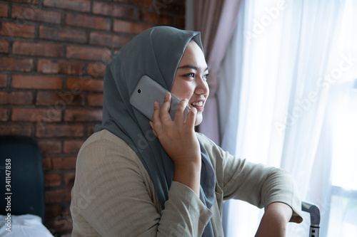 Muslim woman calling by cellphone before go to travelling