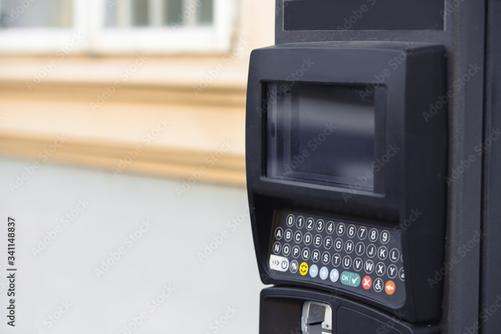 Modern automatic pay Parking meter or ticket payment station on a street allow parkers, car drivers pay by card or cash cryptocurrency in the blurred background. Modern automatic pay Parking meter or ticket payment station on a street allow parkers, car drivers pay by card or cash cryptocurrency in the blurred background.