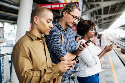 People using smartphones on a train platform © Rawpixel.com