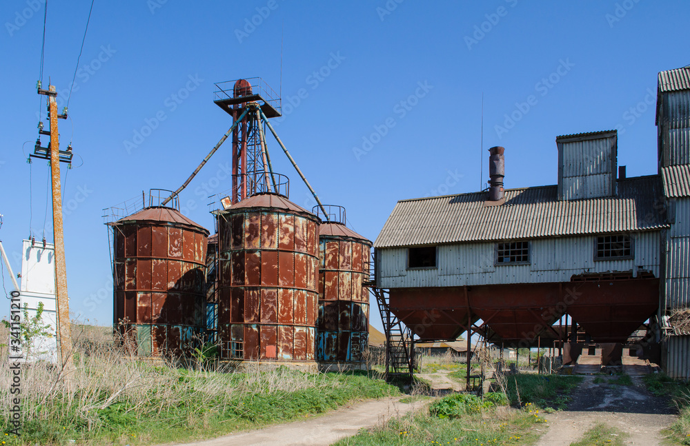 old metal silos for grain, a wooden fence with barbed wire old metal silos for grain, a wooden fence with barbed wire