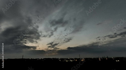 Timelapse of a beautiful sunset with clouds backlit by the sun, in the evening, against the backdrop of a natural landscape and a wide-angle panorama with elements of an industrial landscape photo