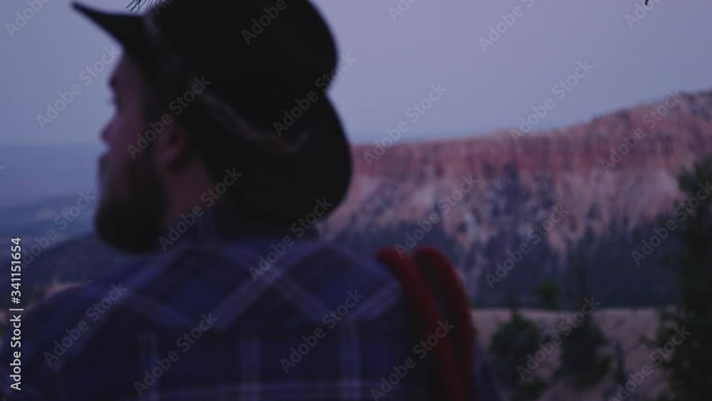 Man looks out over canyon at dusk in Bryce Canyon National Park Man looks out over canyon at dusk in Bryce Canyon National Park