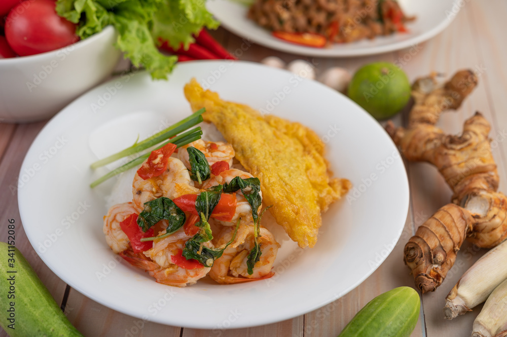 Rice topped with shrimp and omelet on a white plate. Rice topped with shrimp and omelet on a white plate.