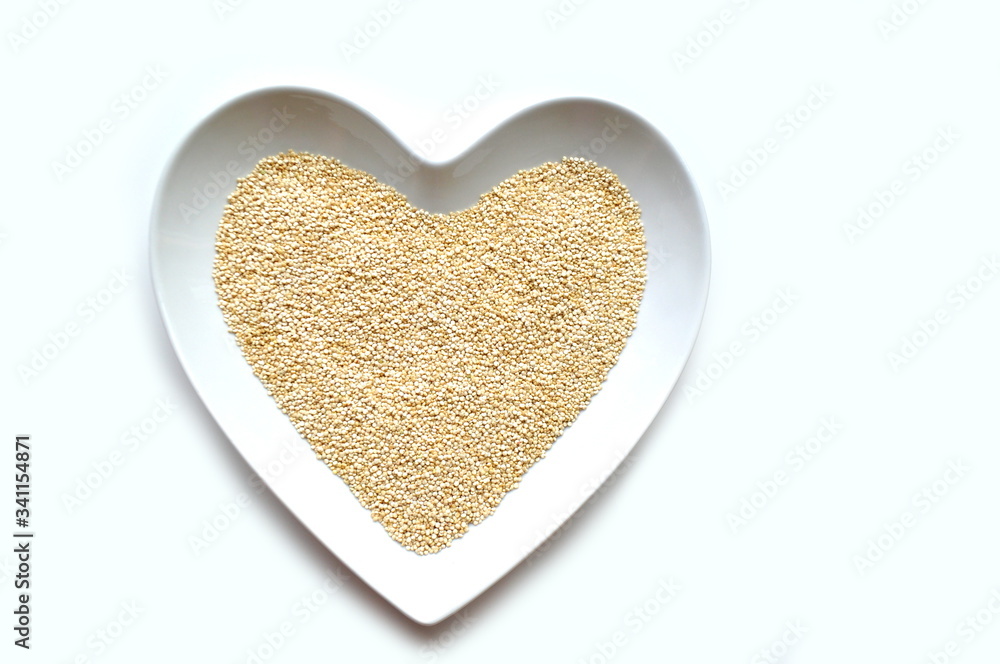 Organic gluten free quinoa grain in a heart shaped bowl on white with copy space Organic gluten free quinoa grain in a heart shaped bowl on white with copy space