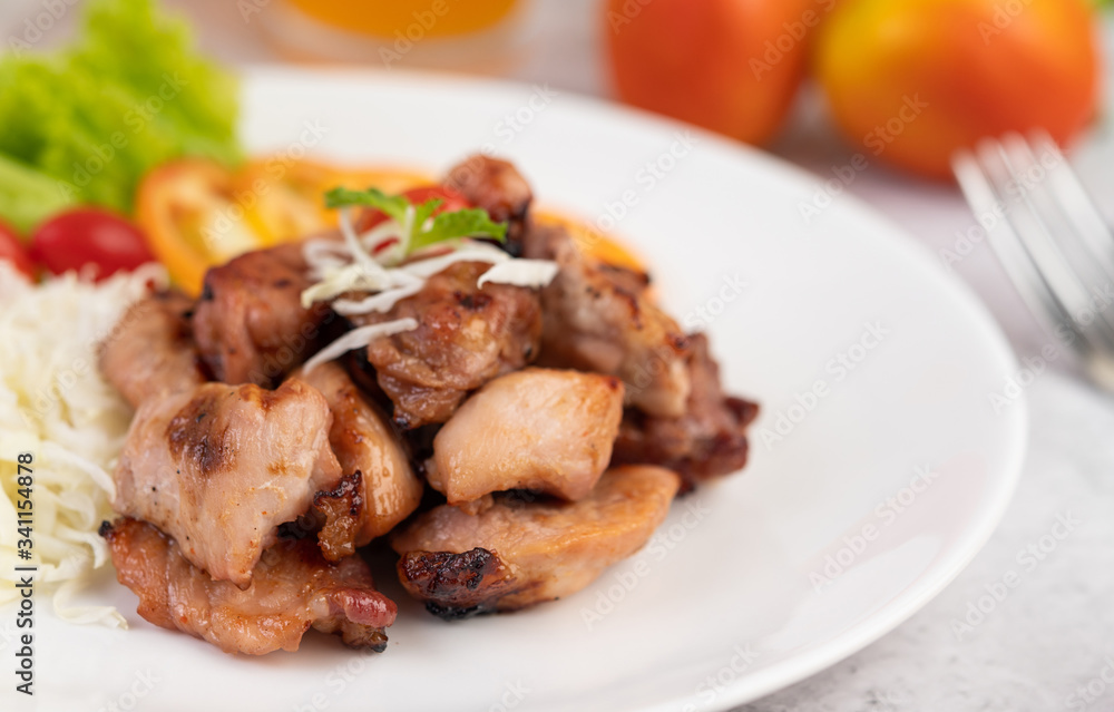 Grilled pork cutlet with tomatoes and salad, arranged in a white dish. Grilled pork cutlet with tomatoes and salad, arranged in a white dish.