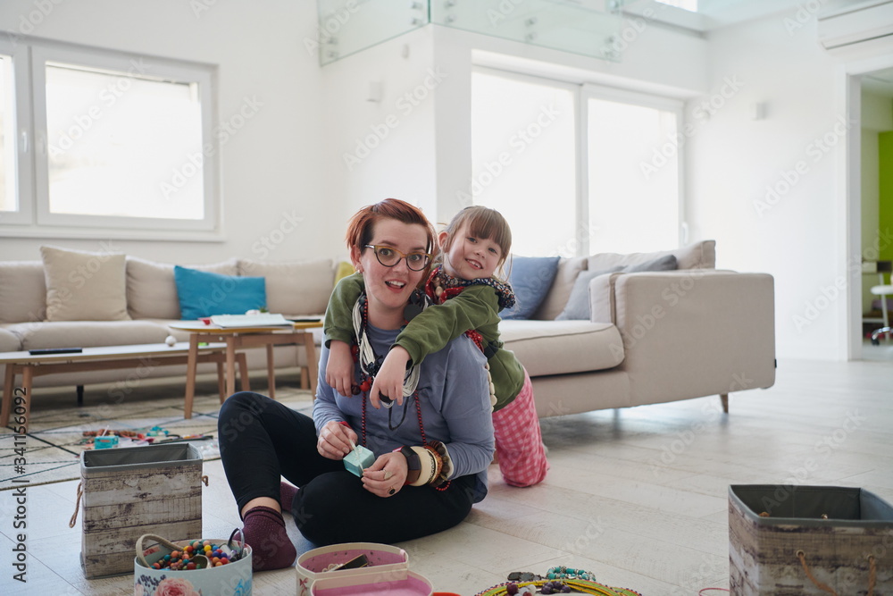 Obraz premium Mother and little girl daughter playing with jewelry at home