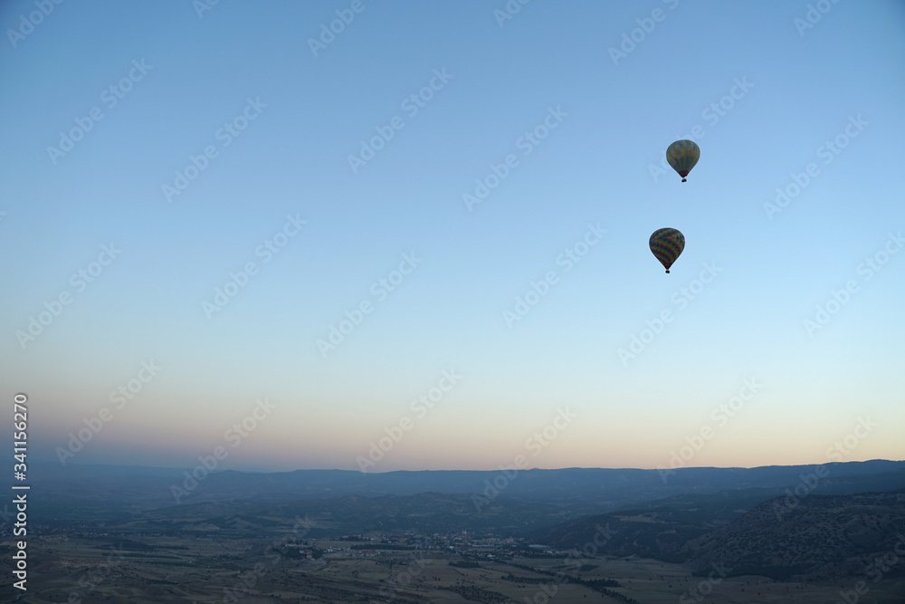 Panoramic view of mountain landscape with hot air balloon floating in the sky Panoramic view of mountain landscape with hot air balloon floating in the sky