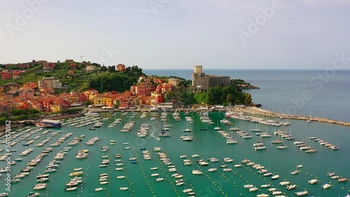 Aerial bird view moving towards Trapani marina showing several sailing boats in the recreational harbor and in background showing Trapani city located in Sicily Italy beautiful summer evening 4k