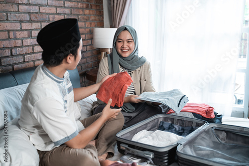 Young Muslim couple prepare luggage together for mudik to home when Eid mubarak