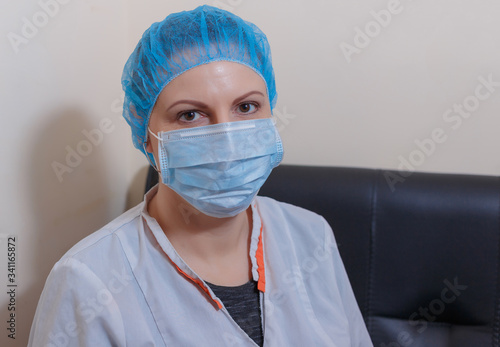 A female doctor in a sterile mask and uniform on a break during the covid-19 coronavirus pandemic