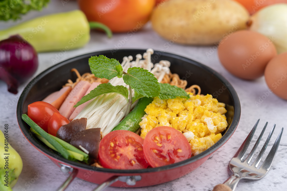 Stir fried noodle that combines corn, golden needle mushroom, tomato, sausage, edamame and spring onions in a frying pan. Stir fried noodle that combines corn, golden needle mushroom, tomato, sausage, edamame and spring onions in a frying pan.