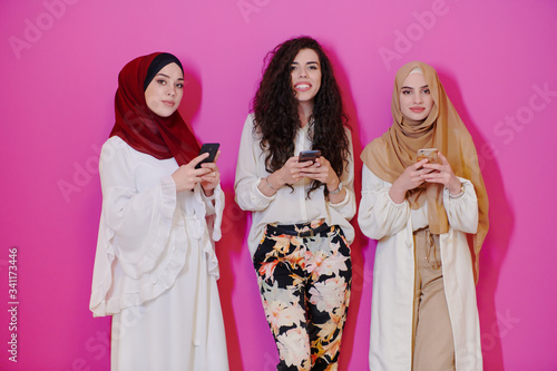 muslim women using mobile phone isolated on pink