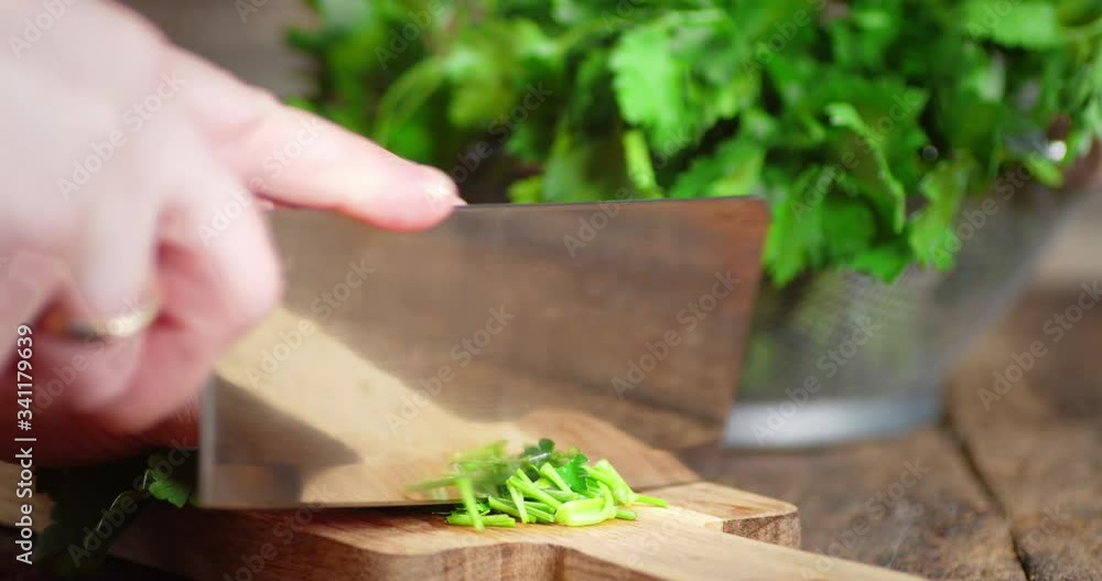Hands men cut a bundle of fresh parsley on a cutting Board. Hands men cut a bundle of fresh parsley on a cutting Board.