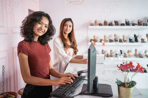 Bilde på lerret beautiful business owner at her fashion shop standing behind the counter and smi