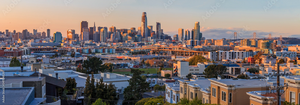 Obraz premium San Francisco city skyline panorama after sunset with city lights, the Bay Bridge and highway leading into the city
