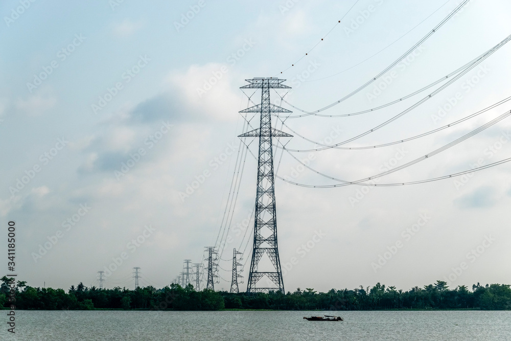 Electric pole crossing river in Mekong Delta. Vinh Long, Vietnam.
