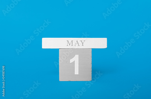 Wooden cubes of a calendar with the date may 1 on a blue background. © Aleksandra