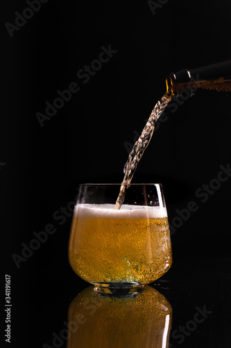 Wallpaper Mural Full glass of nice gold colour fresh beer with air bubbles and white foam on black reflective surface with sprayed water drops on it Torontodigital.ca