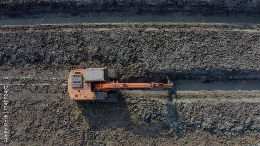 backhoe is digging grove in the agricultural garden area to grow coconuts aerial view footage from drone camera backhoe is digging grove in the agricultural garden area to grow coconuts aerial view footage from drone camera