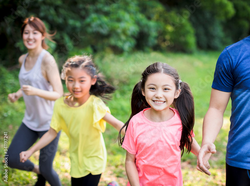 Happy Family with two girls running or jogging in the park