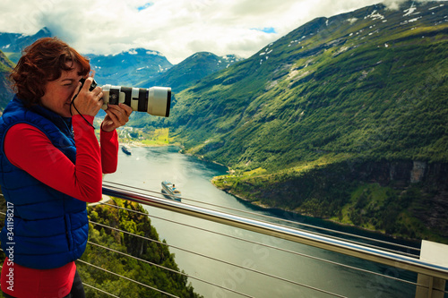 Tourist taking photo of fjord landscape, Norway photo