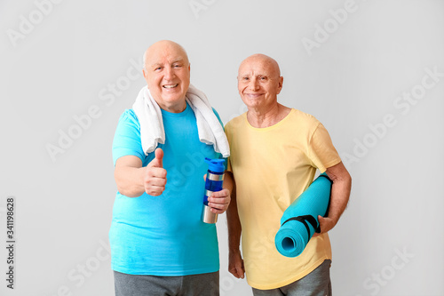 Sporty elderly men with yog...