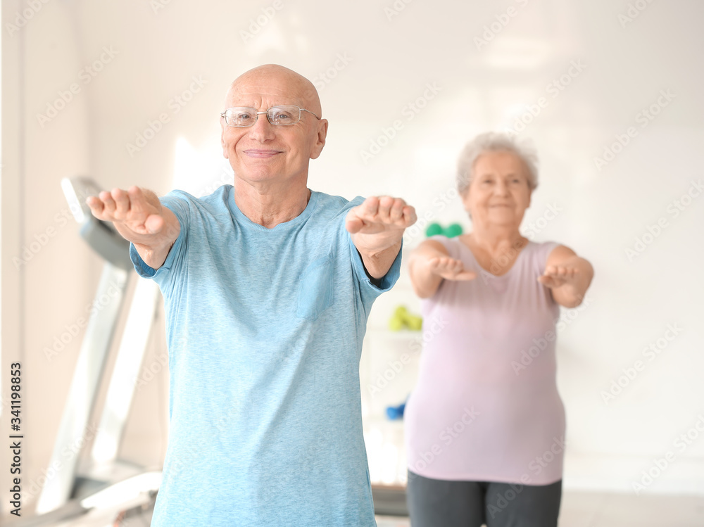Elderly man exercising in gym Elderly man exercising in gym