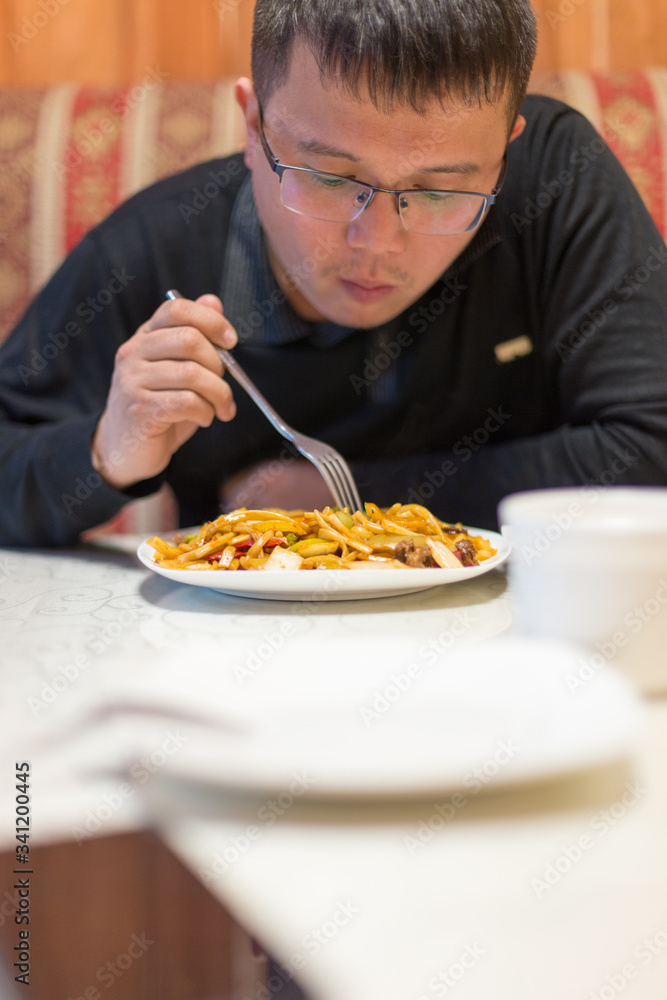Man eating noodles in a cafe during lunch