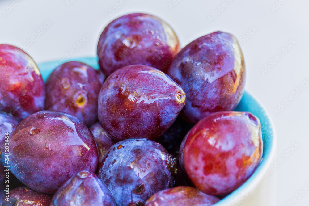 bowl with fresh organic plums- drops