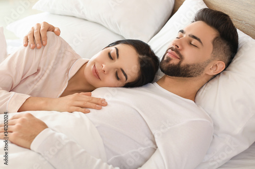 Young couple sleeping in bed at home