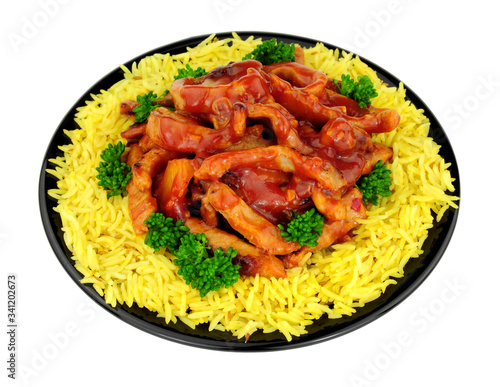 Chinese sweet and sour pork with rice on a black plate isolated on a white background