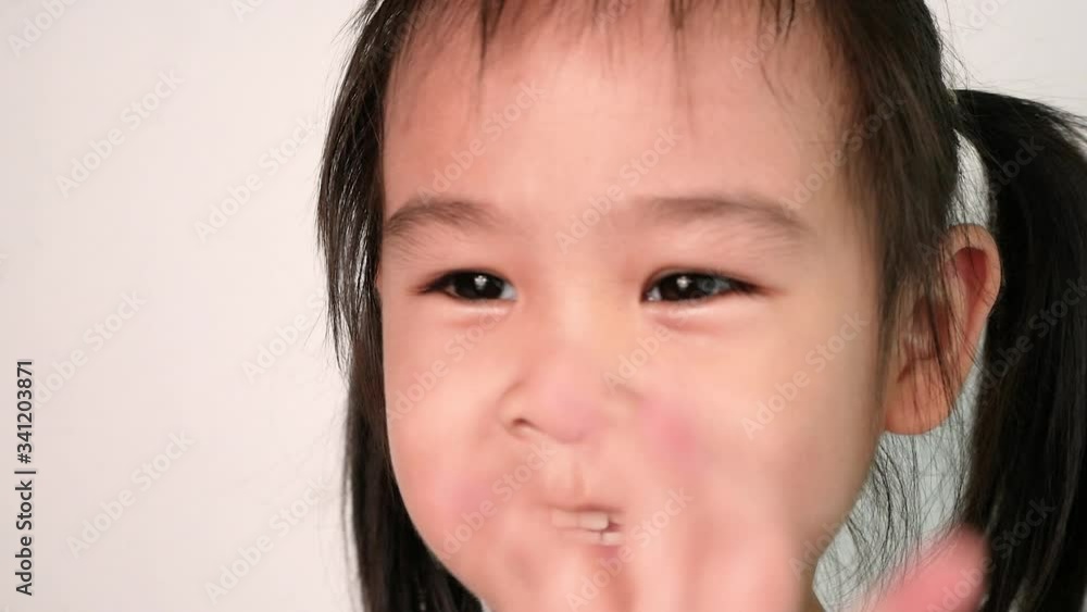 Close up face of Happy Asian little child girl enjoying with dancing and sing song Close up face of Happy Asian little child girl enjoying with dancing and sing song