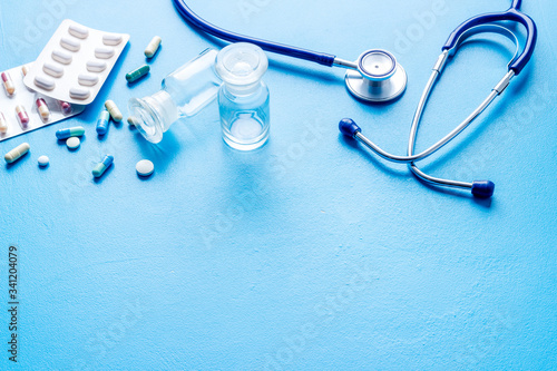 Treatment of influenza or cold. Medicine  stethoscope on blue table copy space