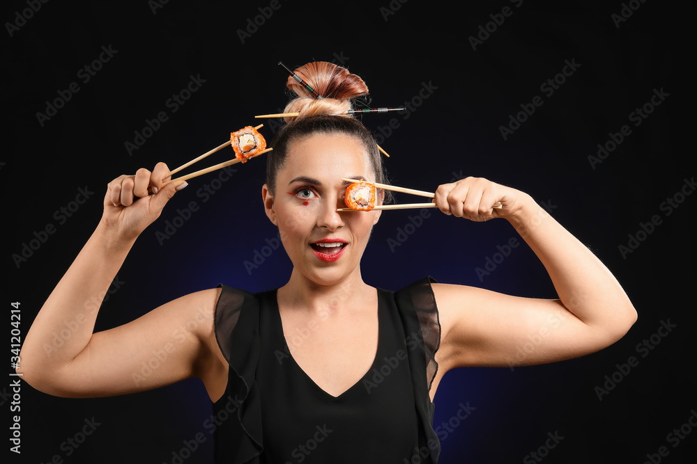 Obraz premium Beautiful woman with tasty sushi on dark background