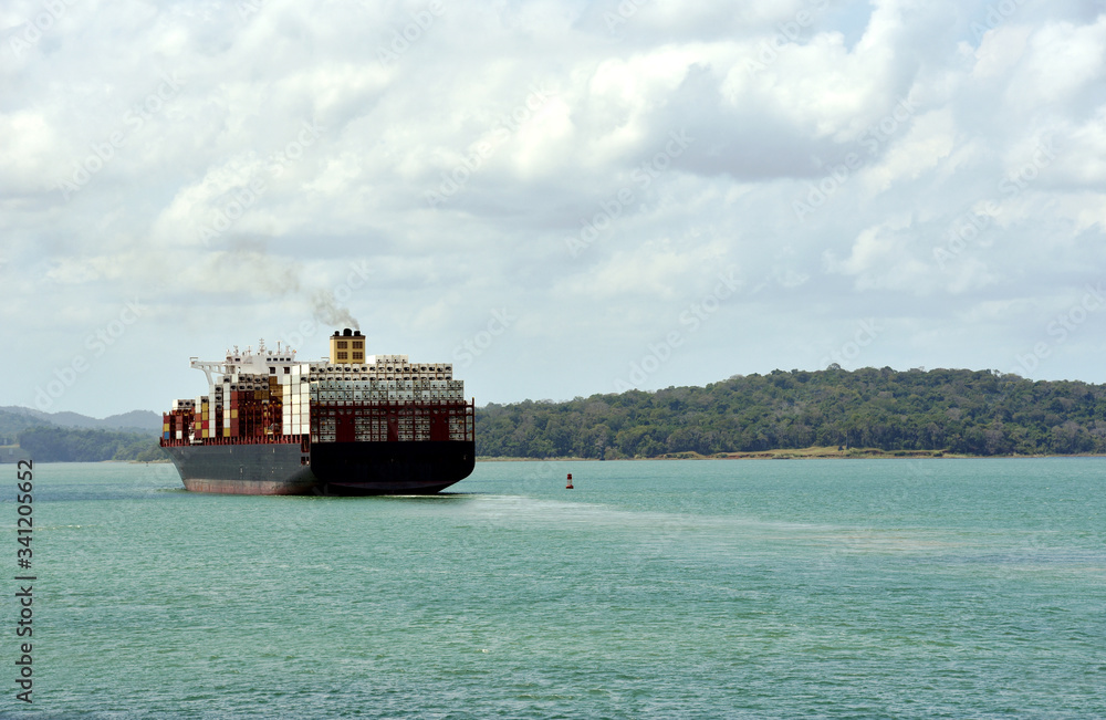 Large container ship sailing through Gatun Lake during her transit through Panama Canal. 