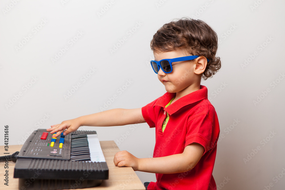 the child arranges a concert at home for parents playing the synthesizer. Imagine the street and the scene in sunglasses. dull and funny quarantine at home.