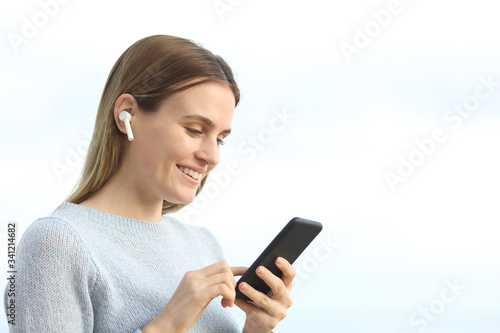 Happy girl listening music on phone with earphones