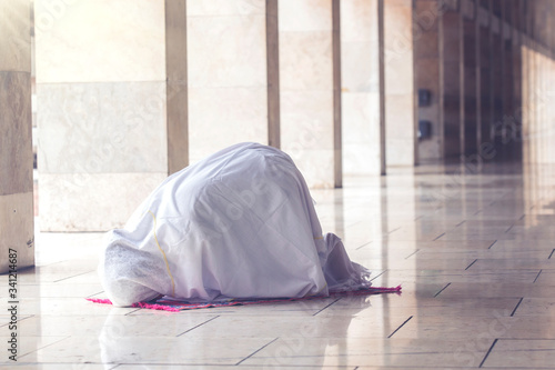 Muslim woman posing prostration in the mosque photo