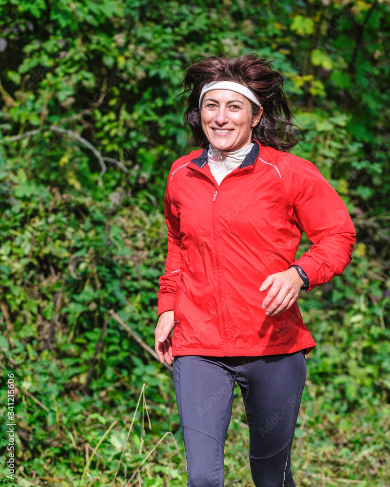 Sportliche Frau beim Waldlauf 