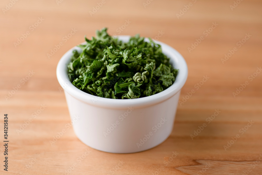 Bowl with tasty fresh greenery over rustic wooden table. Green onion in a bowl. Bowl with tasty fresh greenery over rustic wooden table. Green onion in a bowl.