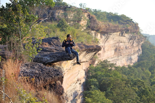 Man sitting on the cliff at Pha Tam National Park, Ubon Ratchathani, Thailand